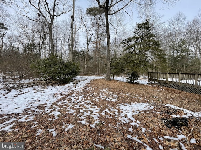 yard covered in snow featuring a deck