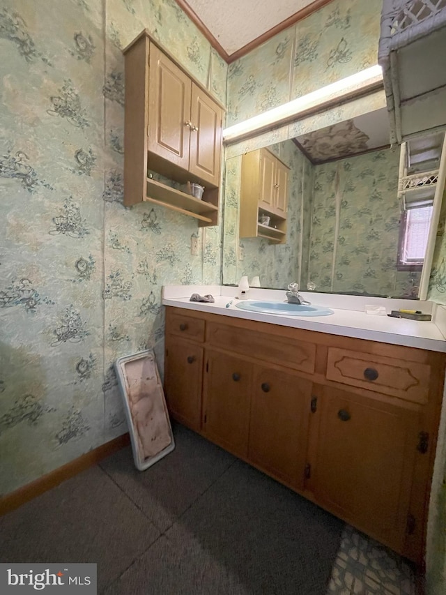 bathroom with wallpapered walls, vanity, and baseboards