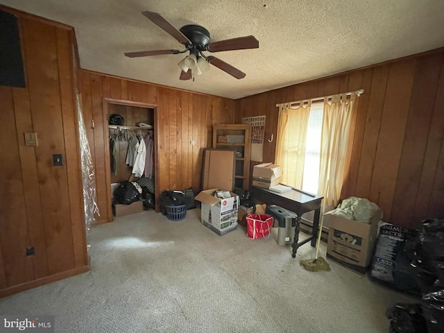 bedroom featuring carpet flooring, a textured ceiling, a closet, and wood walls