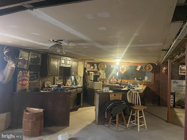 bar with unfinished concrete flooring, a workshop area, and white microwave