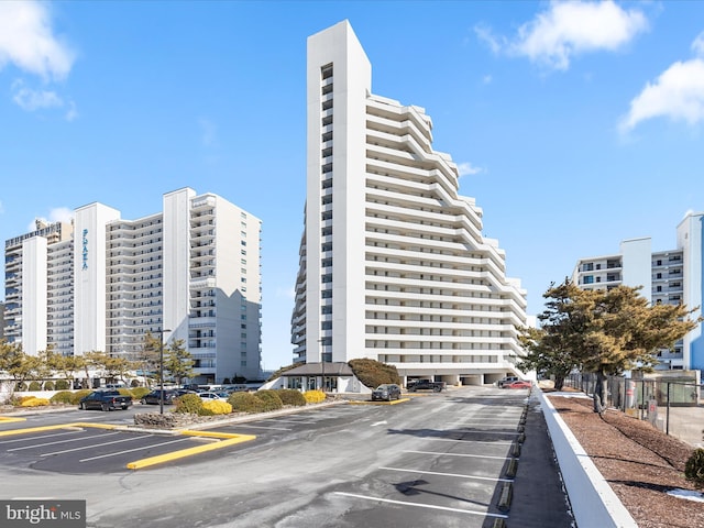 view of building exterior featuring uncovered parking and a city view