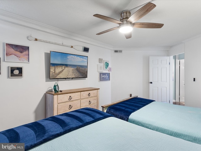 bedroom with a ceiling fan, visible vents, and crown molding