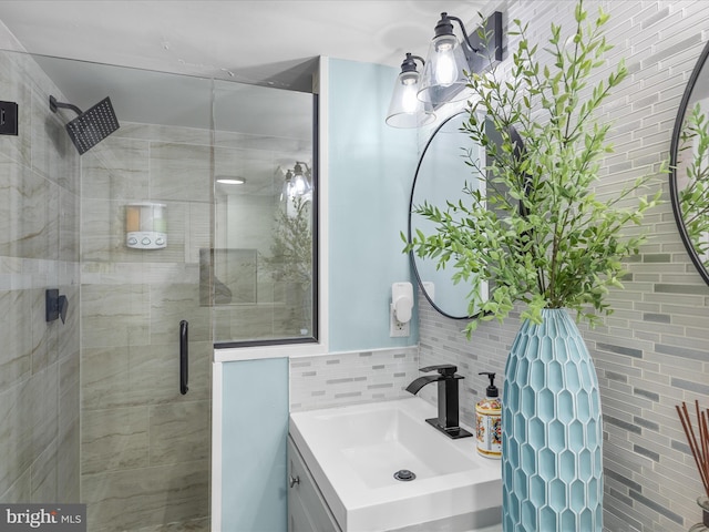 full bath with a stall shower, vanity, and tile walls