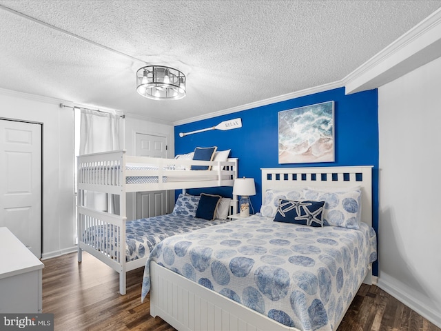 bedroom featuring dark wood-style floors, crown molding, baseboards, and an inviting chandelier