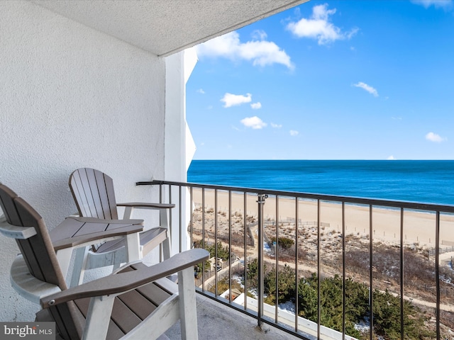 balcony featuring a water view and a view of the beach