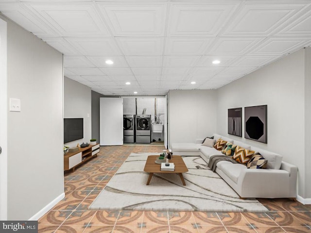 living room featuring washing machine and dryer, baseboards, and recessed lighting