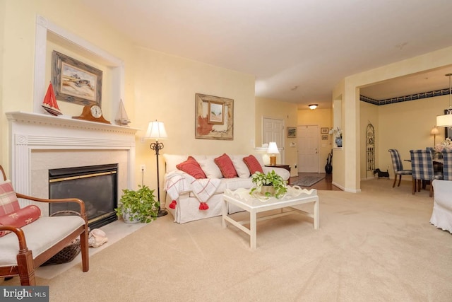 carpeted living area featuring a premium fireplace