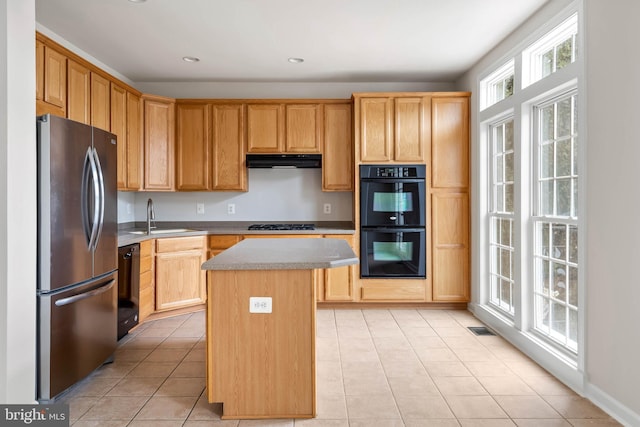 kitchen featuring a center island, light countertops, a sink, under cabinet range hood, and black appliances