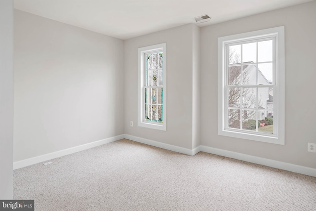 carpeted empty room with baseboards and visible vents