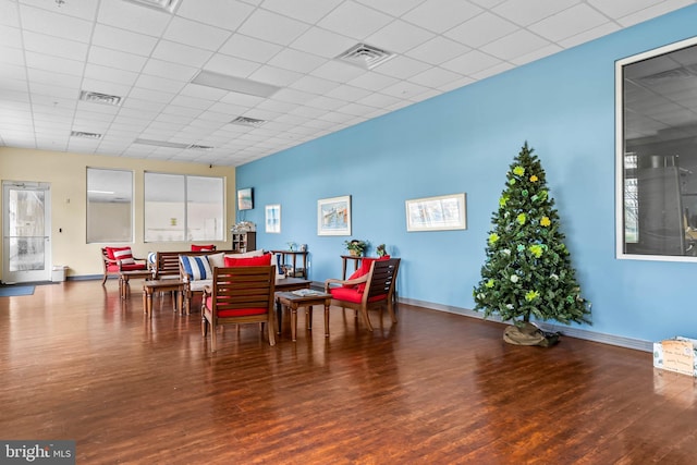 dining area featuring dark wood-type flooring, a paneled ceiling, visible vents, and baseboards