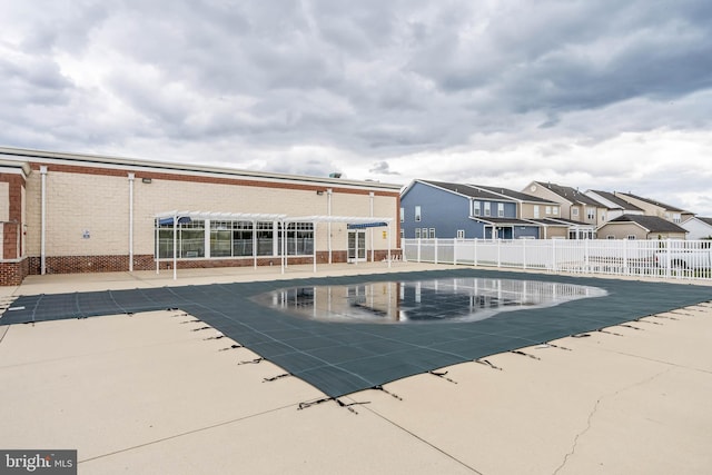 pool featuring a patio area, fence, and a residential view