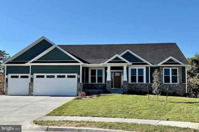 craftsman-style house with stone siding, a front yard, concrete driveway, and an attached garage