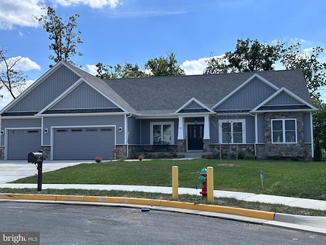 craftsman-style home with driveway, stone siding, roof with shingles, an attached garage, and a front lawn