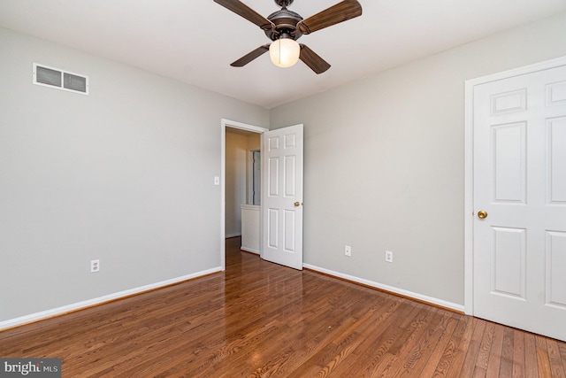 unfurnished bedroom with visible vents, ceiling fan, baseboards, and wood finished floors