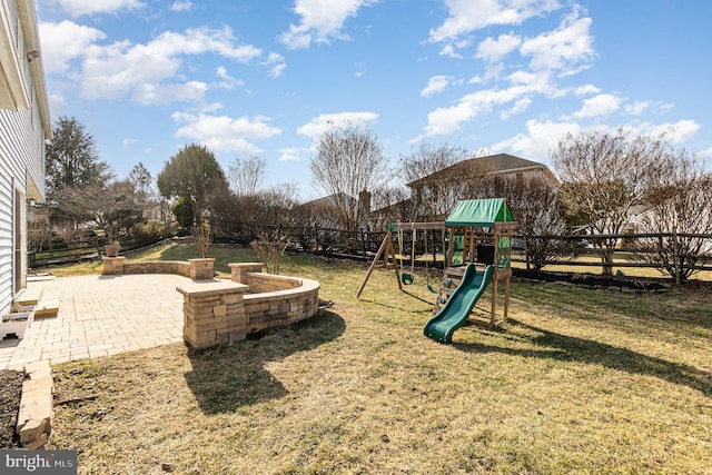 view of jungle gym featuring a patio, a yard, and a fenced backyard