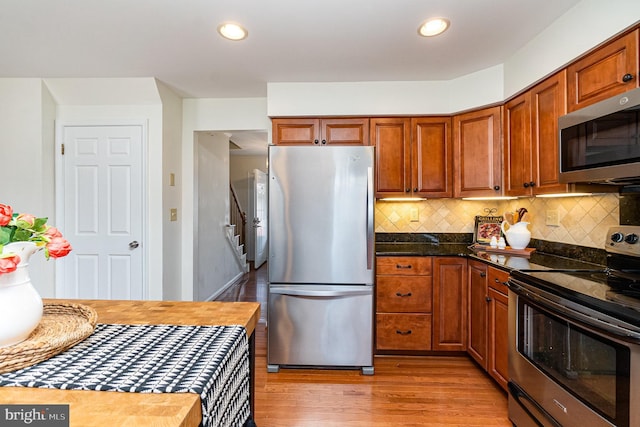 kitchen with light wood-style floors, stainless steel appliances, decorative backsplash, and recessed lighting