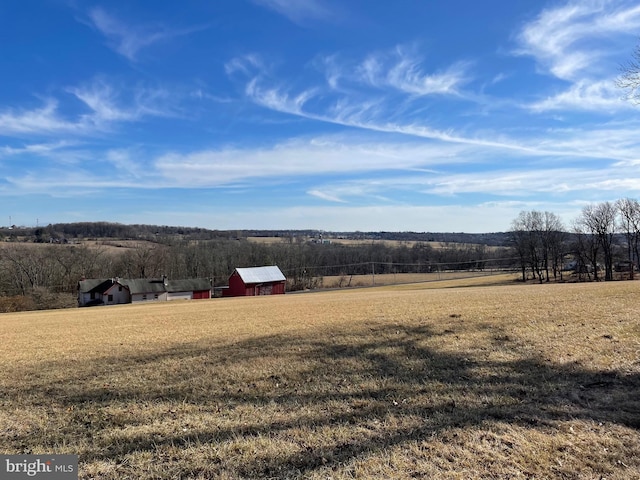 view of yard with a rural view and an outdoor structure