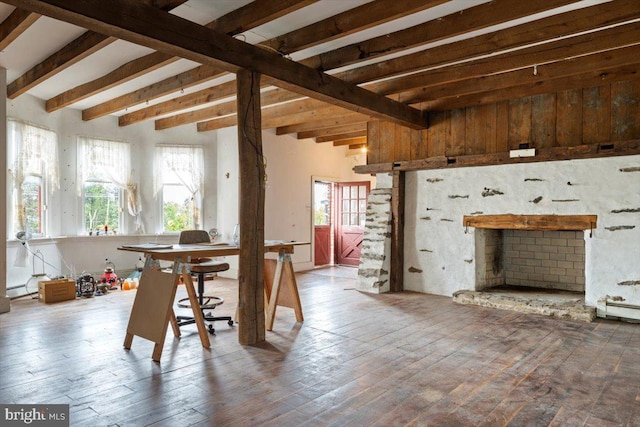 dining area featuring beamed ceiling, a fireplace, and a wealth of natural light