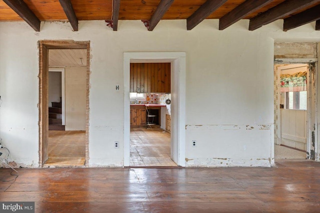 spare room with beam ceiling, stairway, wood finished floors, and wood ceiling