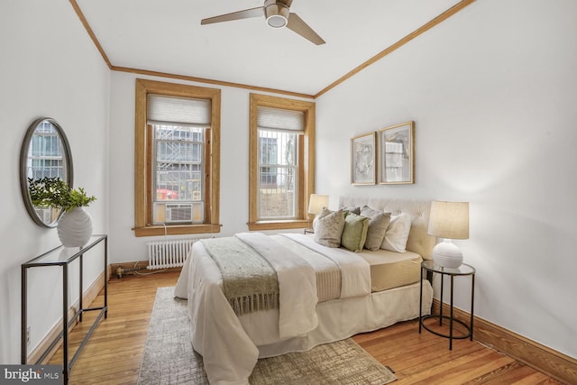 bedroom with ornamental molding, light wood finished floors, baseboards, and radiator