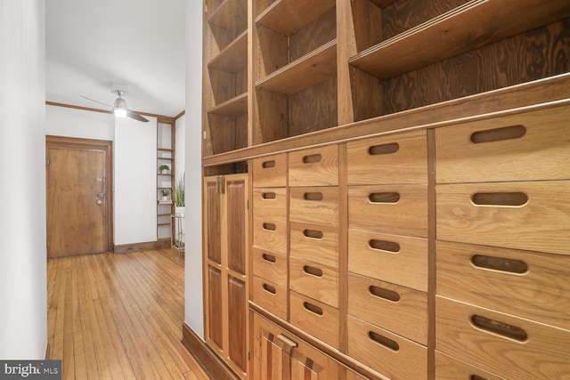 walk in closet with a ceiling fan and light wood-type flooring