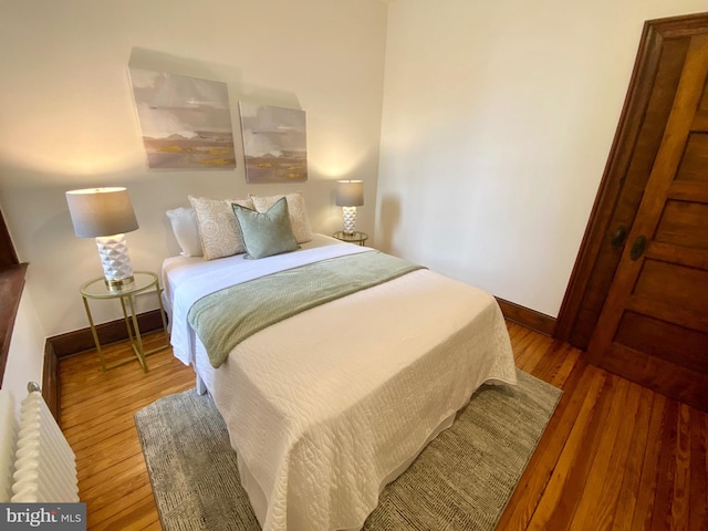 bedroom featuring baseboards and wood finished floors