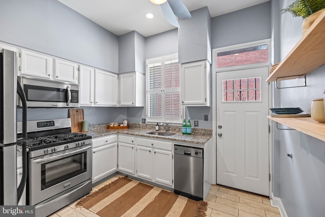 kitchen featuring stainless steel appliances, white cabinetry, open shelves, a sink, and recessed lighting