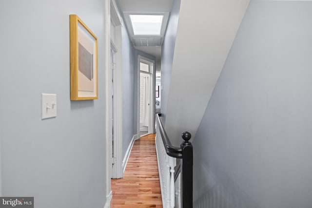 corridor featuring wood finished floors and baseboards