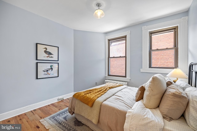 bedroom with baseboards and wood finished floors