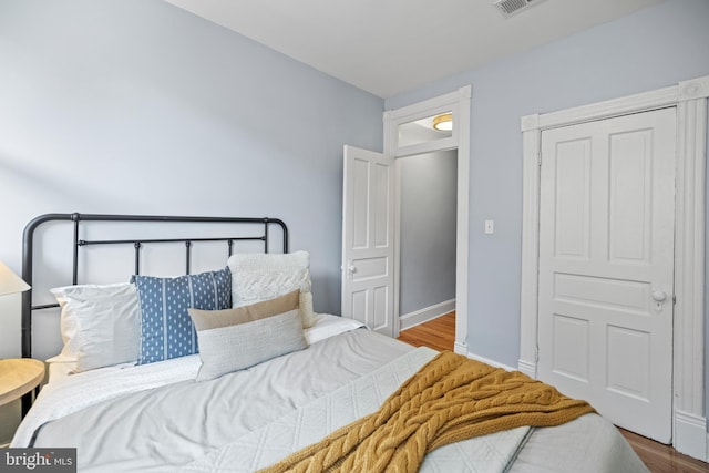 bedroom with baseboards and wood finished floors