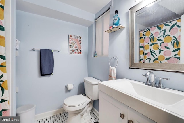 full bath featuring baseboards, vanity, and toilet