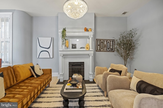 living room with a chandelier, visible vents, and a fireplace