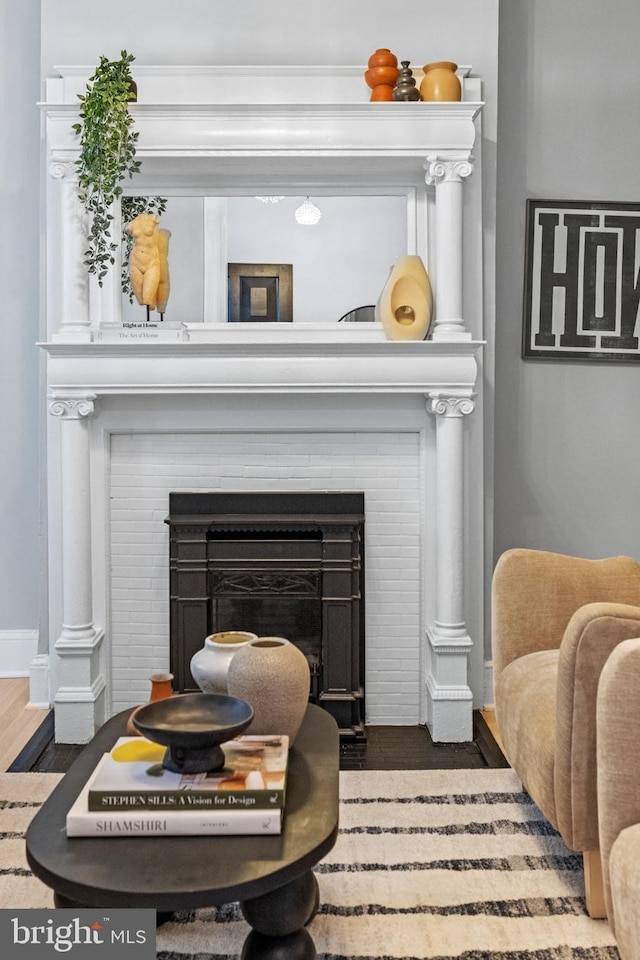 room details with a fireplace, wood finished floors, and baseboards