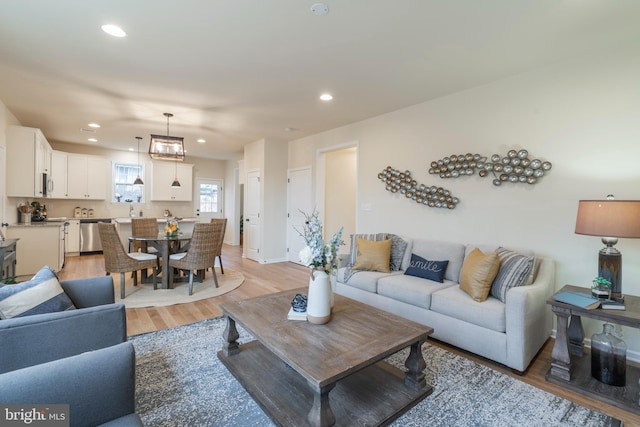 living room with sink and light hardwood / wood-style floors