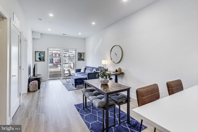 living room featuring baseboards, wood finished floors, and recessed lighting