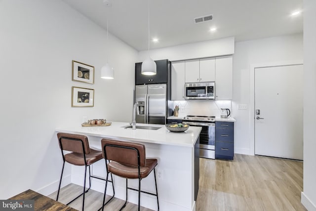 kitchen featuring visible vents, decorative light fixtures, stainless steel appliances, light countertops, and white cabinetry