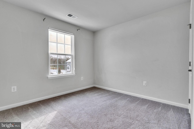 carpeted empty room featuring visible vents and baseboards