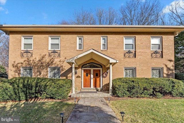 view of front of home with brick siding and a front lawn