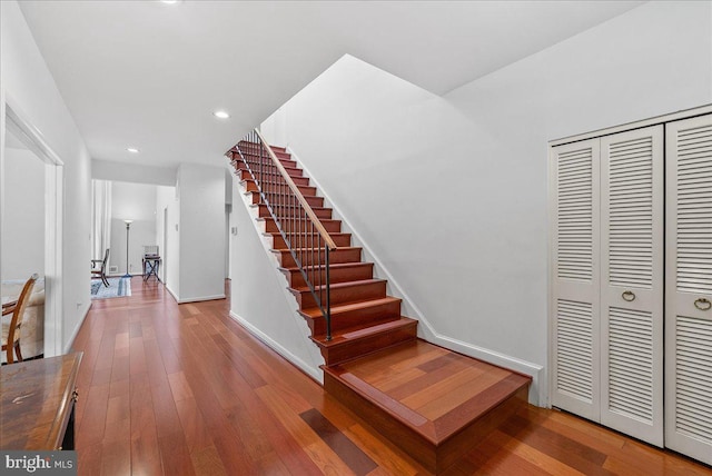 stairway featuring recessed lighting, baseboards, and wood finished floors