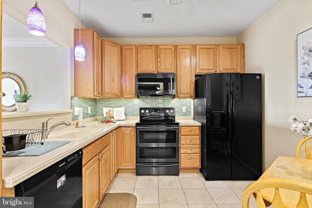 kitchen featuring a sink, light countertops, backsplash, black appliances, and decorative light fixtures