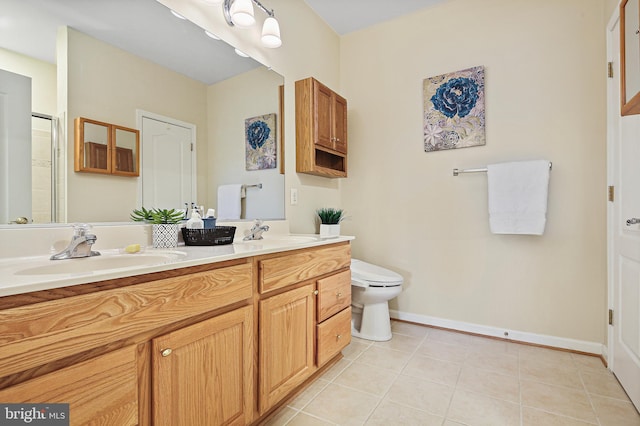 bathroom featuring double vanity, a sink, toilet, and tile patterned floors