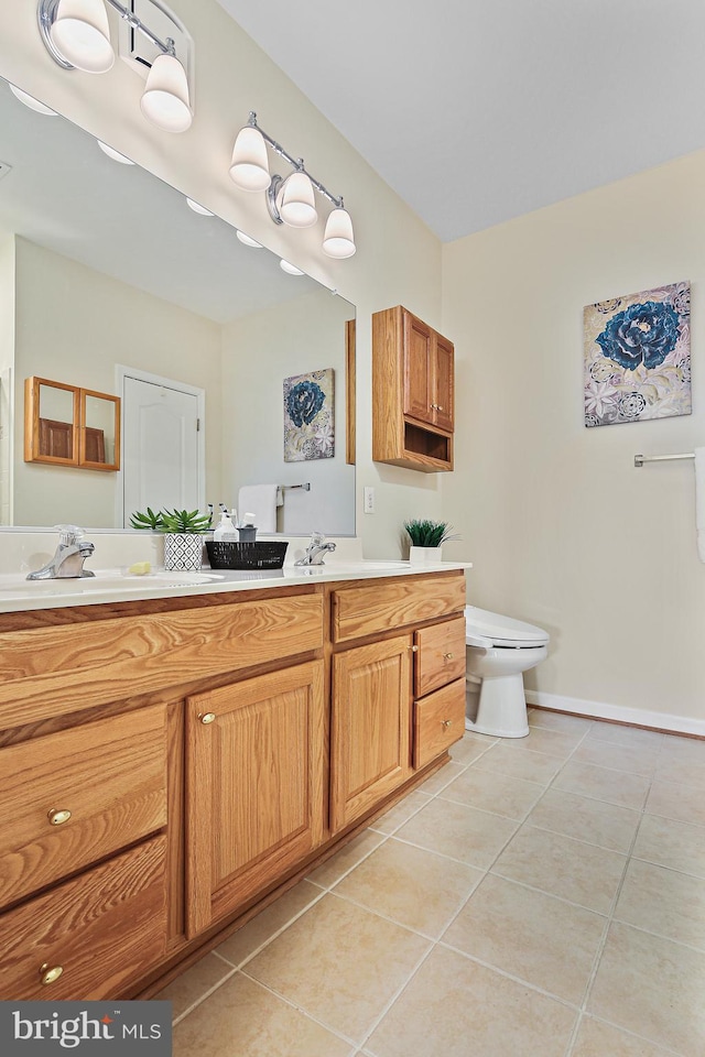 bathroom featuring baseboards, vanity, toilet, and tile patterned floors