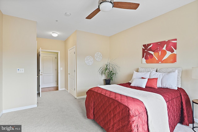 bedroom featuring a ceiling fan, light carpet, and baseboards