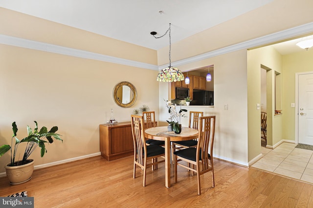 dining room featuring light wood-type flooring and baseboards