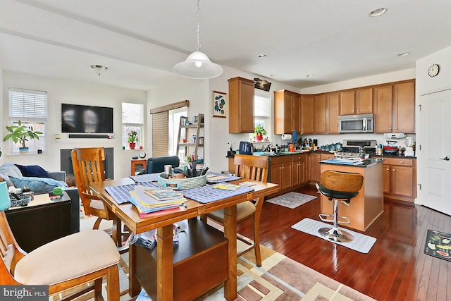 dining area with dark wood-type flooring, recessed lighting, and a healthy amount of sunlight