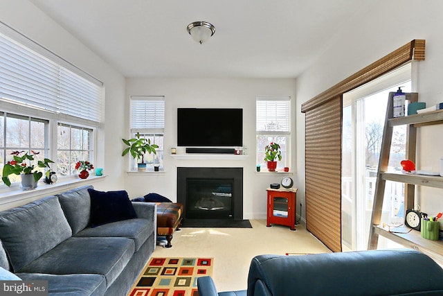 living area with light carpet and a fireplace with flush hearth