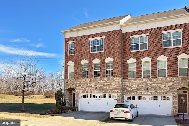 view of front of house with driveway, an attached garage, and brick siding