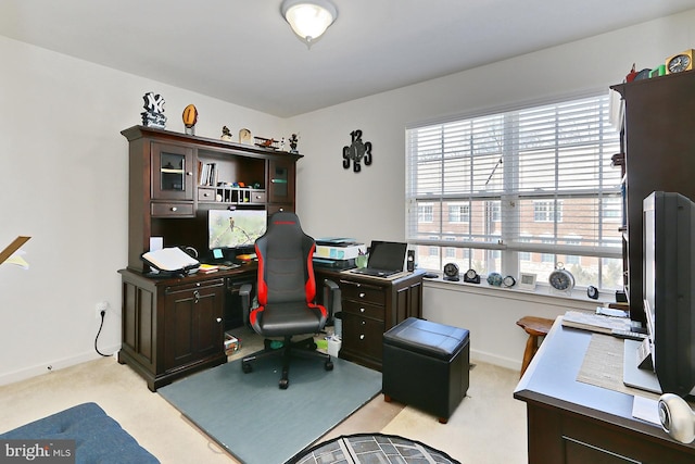 office featuring a healthy amount of sunlight, baseboards, and light colored carpet