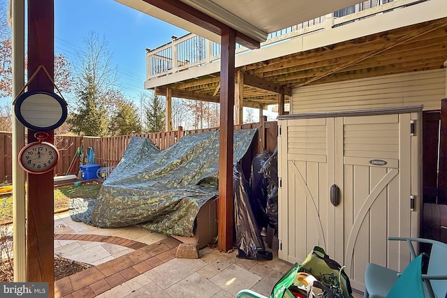 view of patio with a storage unit, an outdoor structure, and a fenced backyard