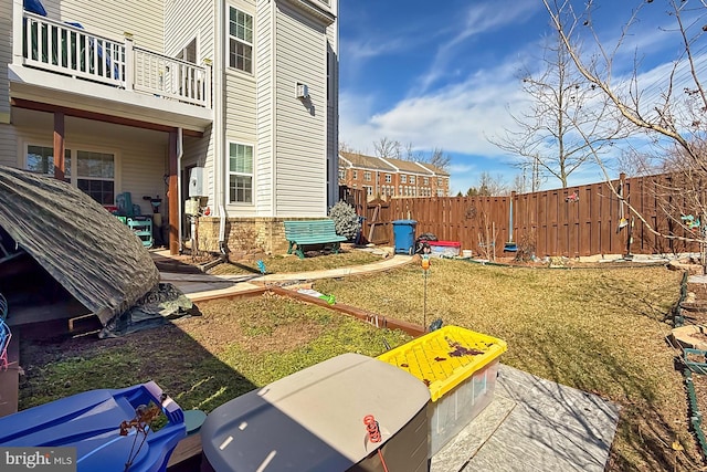 view of yard featuring a balcony and fence private yard